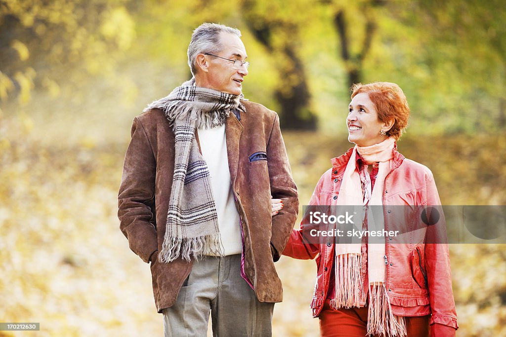 Bella Coppia matura a piedi nel parco. - Foto stock royalty-free di Autunno