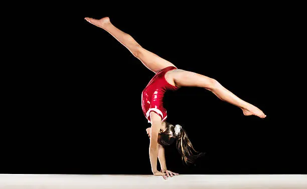 Photo of Young gymnast girl exercising on balance beam.