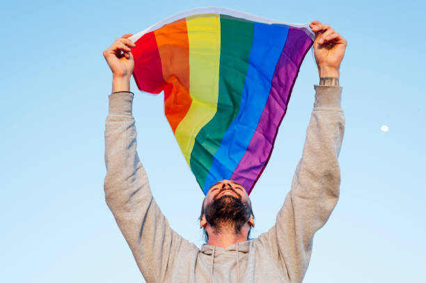 istock Gay man waving lgbt flag 1702146045