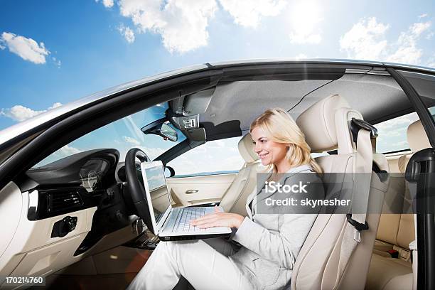 Foto de Linda Mulher Loira Sentando Em Seu Carro E Usando O Laptop e mais fotos de stock de Cabelo Louro
