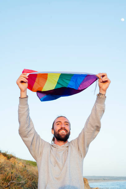 istock Gay man waving lgbt flag 1702147674