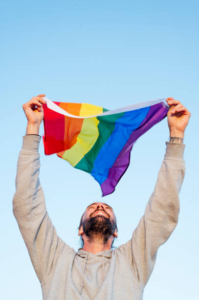 istock Gay man waving lgbt flag 1702147675