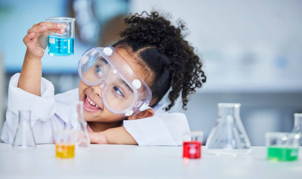 istock Science, eduction and smile with child in laboratory for experiment, learning and research. Future, study and knowledge with face of young girl and chemicals for results, medicine and analysis 1702150092