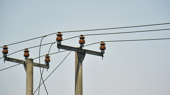 Two electric poles and a long cable