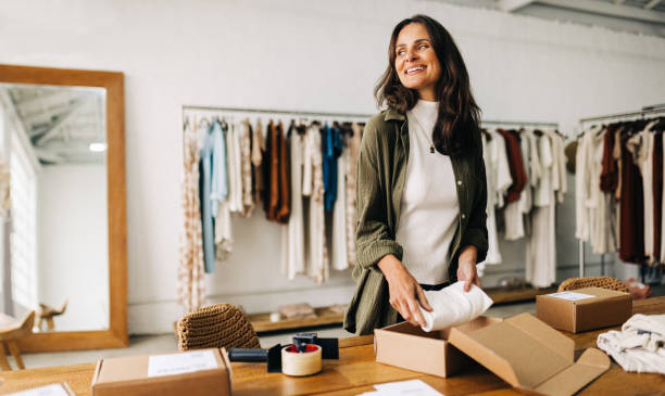 Entrepreneurial spirit drives business woman's dropshipping success With a strong entrepreneurial spirit, this businesswoman prepares a dropshipping order in her clothing boutique, driven to succeed in the world of ecommerce and make her online store a success. small business stock pictures, royalty-free photos & images