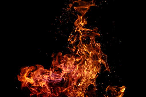 Burning fire with sparks on black background. Can be used as design element in screen add mode or as a text / product placement background.