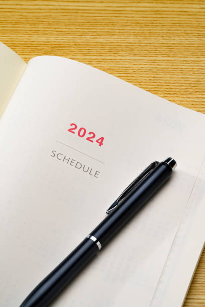 istock 2024 Notebook and pen on wooden table (2024 schedule book) 1702182338