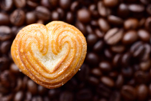 istock Top view of heart shaped biscuit on coffee beans background 1702182847