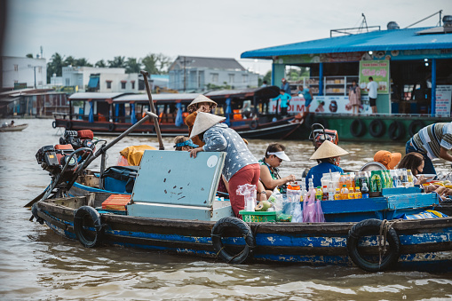 Can Tho, Vietnam - November 5, 2022: female vietnamese merchants selling ggods on boat at floating market in Can Tho, Mekong Delta, south vietnam