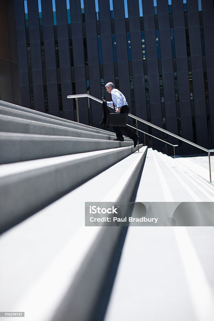 Businessman rushing up steps outdoors  Staircase Stock Photo