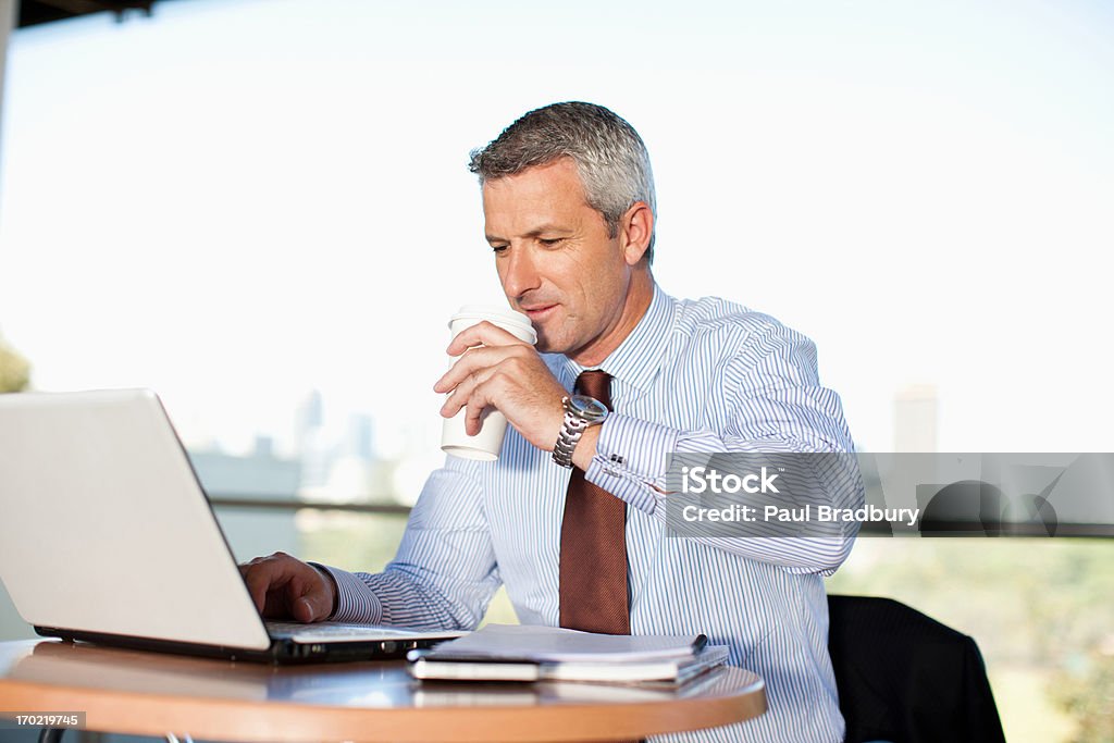 Hombre de negocios utilizando lapto pand bebiendo café en Café - Foto de stock de Ejecutivo libre de derechos