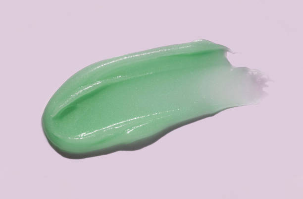 istock Light green cosmetic mask or cleansing foam swatch smudge texture brush stroke cool background 1702204929