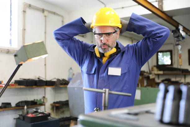 istock An experienced senior factory worker experiencing a problem with production machine trying to solve the problem. Factory interior. 1702204939