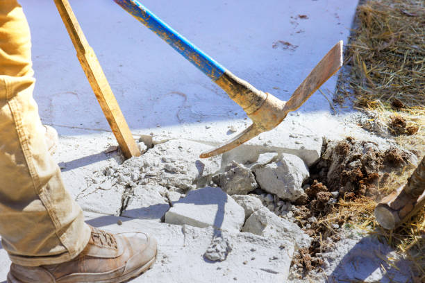 istock Pickaxe wielding worker smashes concrete driveway on construction site 1702223272
