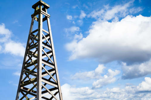 Replica of a 1900's oil derrick against a lovely blue sky.  Room for copy.  Rig located in Jefferson County, Texas.