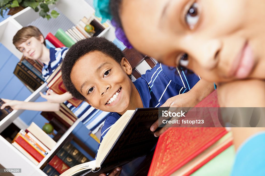 Multiétnico estudiantes 8-12 en la biblioteca de libros. - Foto de stock de 12-13 años libre de derechos