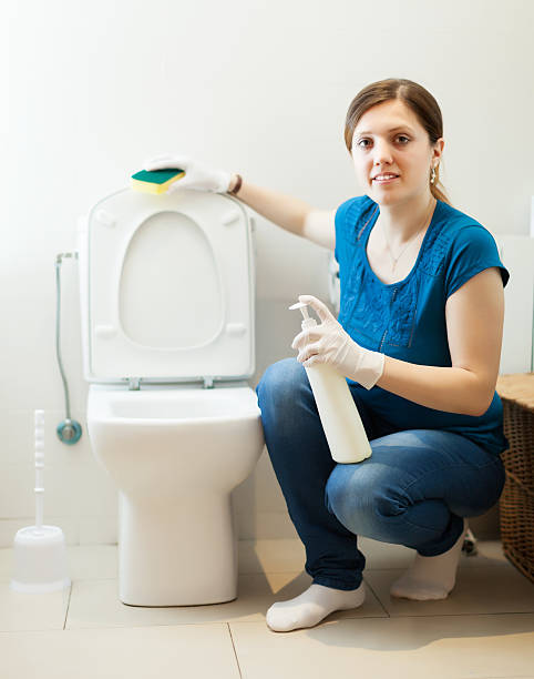 istock woman in bathroom with sponge and cleaner 170224636