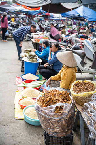 Bac Ha, Vietnam - November 13, 2022: market vendors sitting on street at traditional land market in Bac ha in northern vietnam