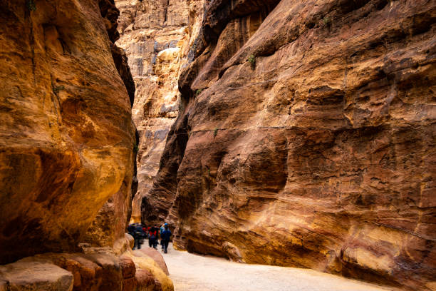 istock Group of tourists in path in Petra 1702259854