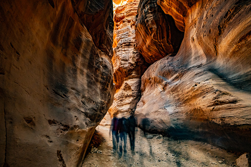 Group of people between sandstone rocks at narrow path in Petra, Jordan