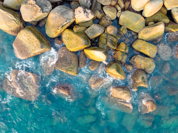 istock Waves crashing on seashore rocks,Top view sea surface waves background 1702268458