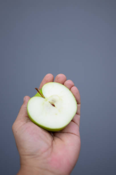 istock Close up hand holding apple fruit 1702272291