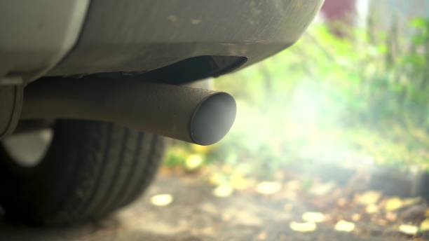 istock Car exhaust pipe close-up. White smoke from a car chimney. 1702276412