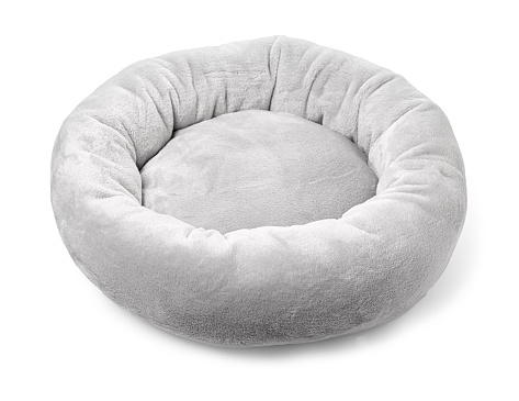 Grey soft round plush pet bed isolated on white