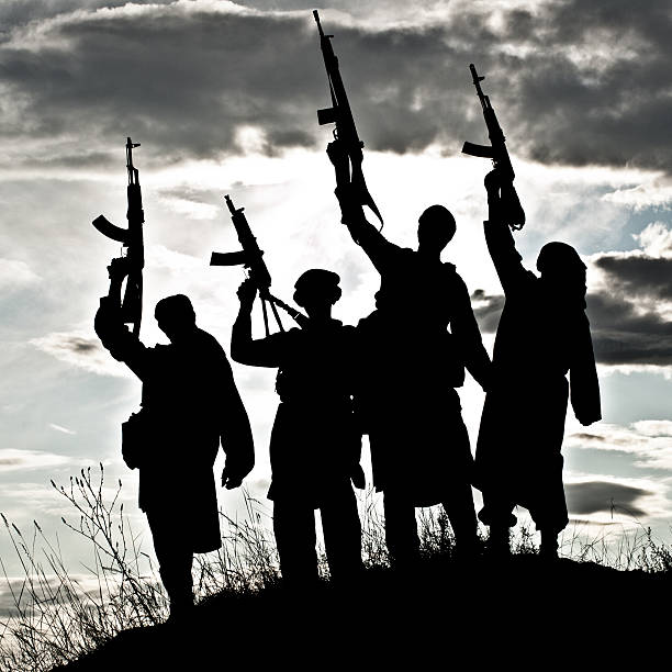 Silhouette of Muslim militants with rifles Silhouette of several muslim militants with rifles terrorism stock pictures, royalty-free photos & images