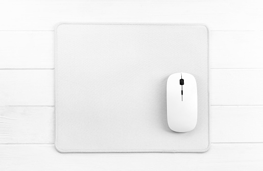 Computer mouse on white mouse pad, top view