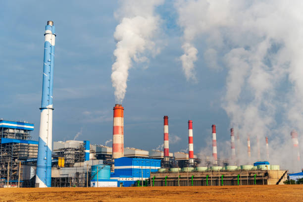 istock Power stations manufacturing electrical industrial plant. Electric power building refinery engineering smog steam smokestack. Lignite electricity chimneys release pollution in industry plant blue sky 1702306540