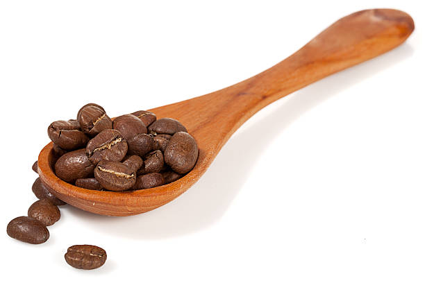 istock wooden spoon with coffee beans isolated over white 170231034