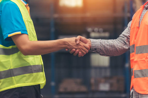 istock Close up warehouse worker shakehand together. Engineer man hands partnership. Diversity Coworker Men logistics Warehouse teams handshake. Multiracial Support team greeting person teamwork colleagues 1702314008