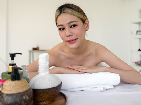A serene woman reclining leisurely within a soothing spa ambiance, surrounded by elements promoting tranquility. Holistic luxury wellness experience.