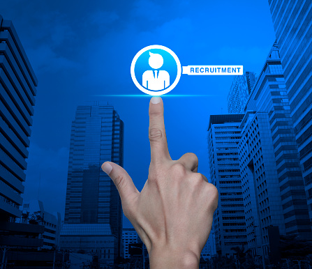 Hand pressing businessman with magnifying glass icon over modern city tower and skyscraper, Business recruitment service concept