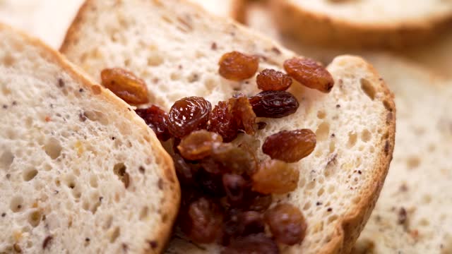 Gluten free sliced white bread with falling raisins. Dietary nutritious healthy food for celiacs. Closeup. Slow motion