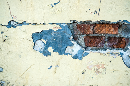 old rough wall background with cracks and bricks