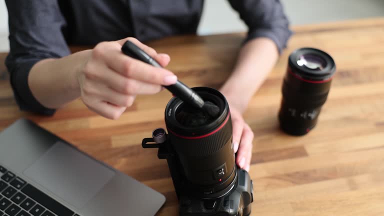 Female hands cleaning camera lens with lens cleaning system