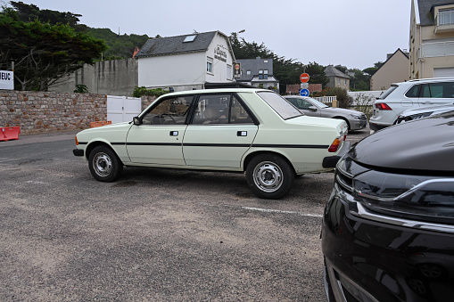Erquy, France, September 3, 2023 - Peugeot 505 vintage car in a parking lot on Erquy beach. The Peugeot 505 was produced in this form between 1979 and 1985.