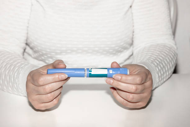 Insulin injection pen or insulin cartridge pen for diabetics. Medical equipment for diabetes parients. Woman holding an injection pen for diabetic.