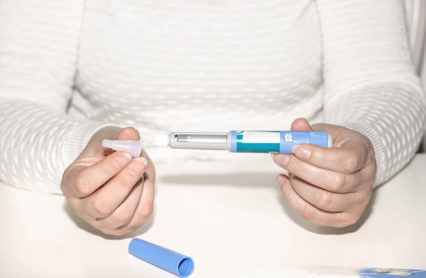 istock Woman holding an injection pen for diabetic. 1702335549
