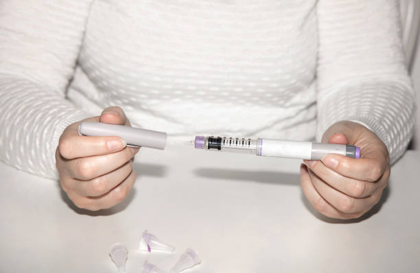 istock Woman holding an injection pen for diabetic. 1702335832