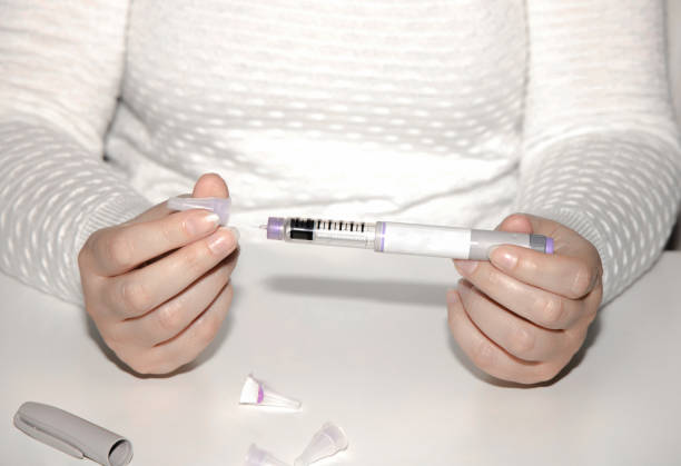 istock Woman holding an injection pen for diabetic. 1702335838