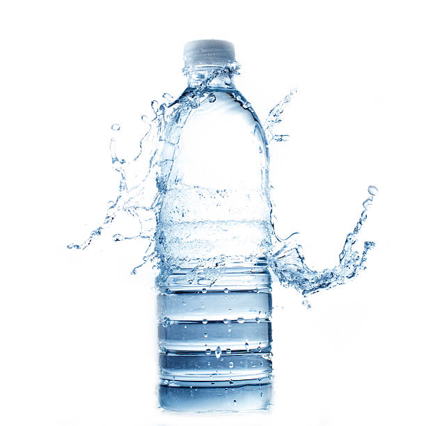 Water splashing onto full plastic water bottle stock photo