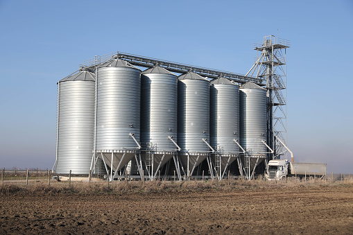 Silo in beautiful landscape with dramatical light placed in plouged acres