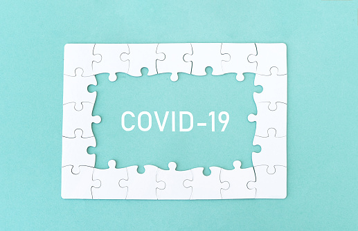 Top view of jigsaw puzzle with COVID-19