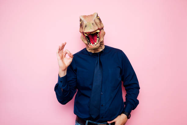 istock Man with euphoric dinosaur head and fingers with ok symbol 1702358197