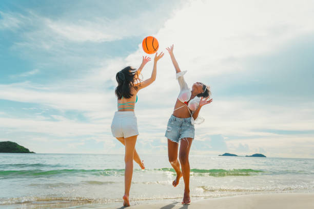 istock beautiful woman playing ball on the beach 1702378495