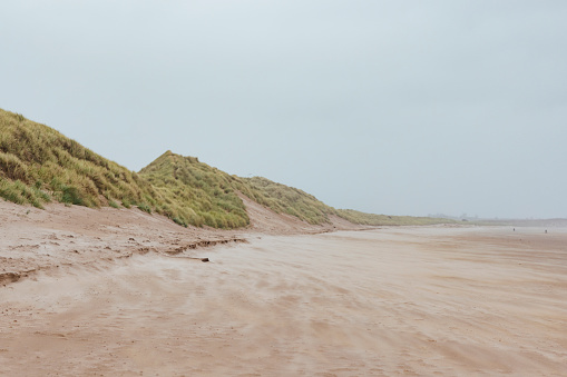 This image shows a windy Alnwick sand dune with grassy hill tops.