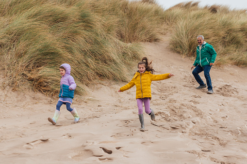 A heartwarming sight unfolds on Alnwick Beach as two young sisters run down a sandy dune, their laughter filling the air, while their beaming grandfather joins in on the playful adventure. This joyful moment captures the essence of family bonds and the simple pleasures of a day by the sea.
There is video to match this scenario.